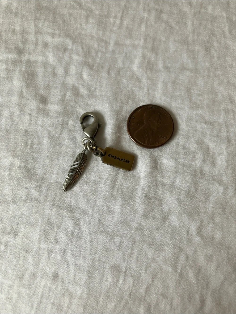 Coach: Silver Tone & Gold Tone Feather Charm Keyring